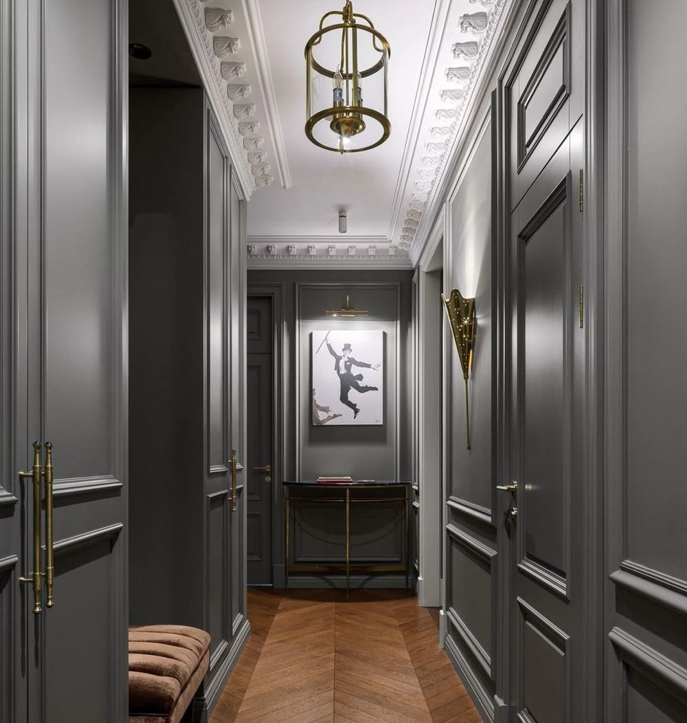 Couloir aux murs gris anthracite, corniche blanche sculptée et parquet en chevrons